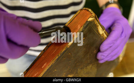 St Mary's Church Library Entfernung. Eines der Bücher aus einer ganzen Pfarrbibliothek in der St. Mary's Church in Nantwich, Cheshire, wird gereinigt. Stockfoto