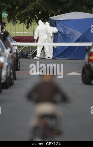 Der Körper eines Mannes in den Zwanzigern wird aus der Szene entfernt, in der er in Ballyfermot, Co Dublin, getötet wurde. Stockfoto