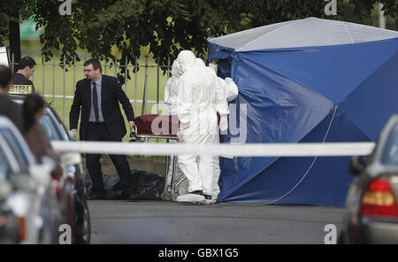 Mann schoss tot. Der Körper eines Mannes in den Zwanzigern wird aus der Szene entfernt, in der er in Ballyfermot, Co Dublin, getötet wurde. Stockfoto