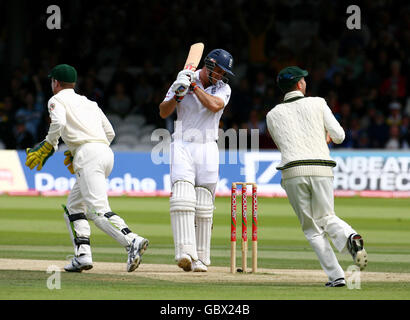 England Kapitän Andrew Strauss (Mitte) schaut nach unten, als er das Feld verlässt, nachdem er sein Wicket verloren hat, während der australische Wicketkeeper Brad Haddin (links) und Teamkollege Michael Clarke am dritten Tag des zweiten npower Test Spiels in Lord's, London feiern. Stockfoto