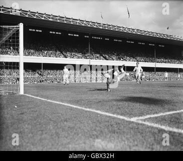 Manchester United Torwart David Gaskell (c) macht einen Tauchgang retten, beobachtet von den Teamkollegen Tony Dunne (l) und Nobby Lawton (r) Stockfoto