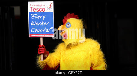 Ein als Huhn gekleideter Protestler demonstriert vor der Tesco-Jahresversammlung im Scottish Exhibition and Conference Centre in Glasgow. Stockfoto