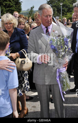 Der Prinz von Wales erhält einen Blumenstrauß und die Herzogin von Cornwall kommt in die Penair School, Truro, Cornwall. Stockfoto