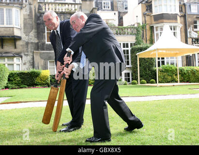 Der ehemalige australische Premierminister John Howard AC und ein Direktor der Bradman Foundation (rechts) sowie Michael Ball, Vorsitzender der und der Bradman Foundation, stellen sich vor Fotografen in London, Nach einem Cricket-Schläger von Sir Donald Bradman verwendet wurde, um die Stiftung von den Brüdern Martin und Eugene Withers aus Schottland vorgestellt. Stockfoto