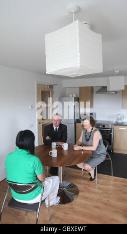 Communities Minister Alex Neil und Lydia Okroj (rechts) von Scottish Womans Aid, chattet mit einem nicht identifizierten Missbrauchsopfer an einem neuen Zufluchtsort für Frauen und Kinder, die von häuslicher Gewalt in Glasgow betroffen sind. Stockfoto