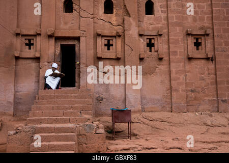 ein Priester liest einen alten Schrift außerhalb einer alten Kirche in Lalibela, Äthiopien Stockfoto