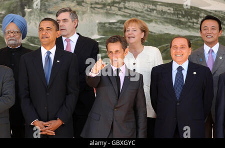 G8-Führer und G5-Führer posieren für das Familienfoto. (Von links nach rechts) der indische Premierminister Manmohan Singh, US-Präsident Barack Obama, der britische Premierminister Gordon Brown, der französische Präsident Nicolas Sarkozy (gestikuliert an den kanadischen Premierminister Stephen Harper, der zu spät kommt), die deutsche Kanzlerin Angela Merkel, der italienische Premierminister Silvio Berlusconi und der japanische Premierminister Taro Aso, Am zweiten Tag des G8-Gipfels in L'Aquila, Italien. Stockfoto