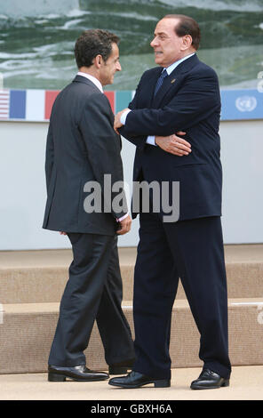 Der französische Präsident Nicolas Sarkozy (links) wartet mit dem italienischen Ministerpräsidenten Silvio Berlusconi auf den Beginn des G8-Familienfotos während des G8-Gipfels in L' Aquila, Italien. Stockfoto