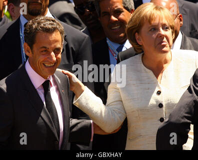 Bundeskanzlerin Angela Merkel und der französische Präsident Nicolas Sarkozy machen sich auf die Bühne, auf der die Staats- und Regierungschefs der G8-Staaten und der G5-Staaten am zweiten Tag des G8-Gipfels in L'Aquila, Italien, für ein "Familienfoto" posieren werden. Stockfoto