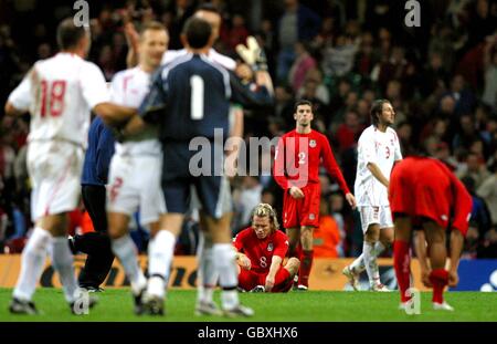 Die walisischen Spieler Craig Bellamy, Mark Delaney und Robert Earnshaw sind niedergeschlagen, als Polen den Sieg feiern Stockfoto