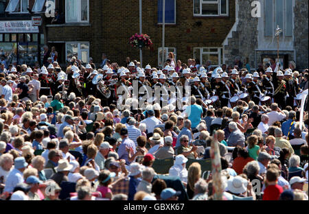 Mitglieder der Royal Marine Collingwood Band marschieren den Strand auf Deal Seafront in Kent entlang, um ein Gedenkkonzert auf dem Memorial Bandstand auf Deal Seafront, Kent, zu geben. Stockfoto