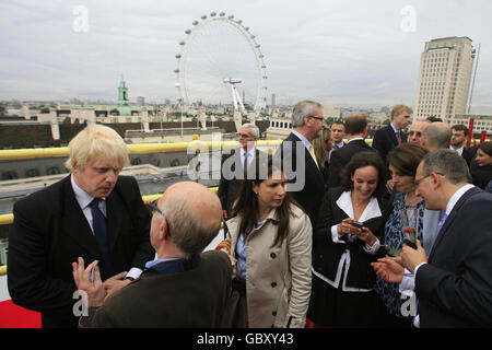 Der Bürgermeister von London Boris Johnson (links) wird von den Medien interviewt, während er an einer Richtfeier im 13. Stock des Park Plaza Westminster Bridge Hotels auf der Südseite der Westminster Bridge in London teilnimmt. Stockfoto