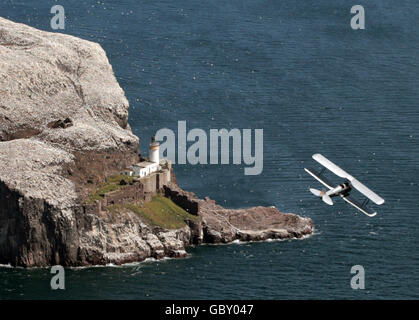 Ein Doppeldecker der Tiger Moth, der von David Cyster gesteuert wurde, manövriert über Bass Rock, East Lothian, vor der Flugschau des National Museum of Flight im East Fortune am 25. Juli. Stockfoto
