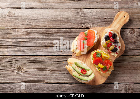 Toast-Sandwiches mit Avocado, Tomaten und Lachs auf hölzernen Hintergrund. Draufsicht mit Textfreiraum Stockfoto