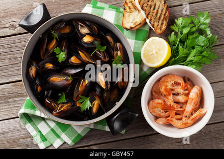 Muscheln und Garnelen auf Holztisch. Ansicht von oben Stockfoto