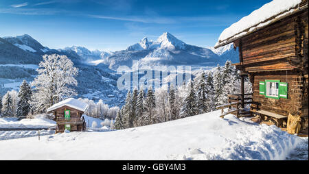 Panoramablick auf der schönen Winter Wunderland Bergwelt der Alpen mit traditionellen Berghütten an einem kalten, sonnigen Tag Stockfoto