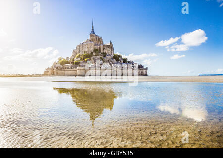 Klassische Ansicht des berühmten Le Mont Saint-Michel-Gezeiten-Insel an einem sonnigen Tag mit blauem Himmel und Wolken, Normandie, Nordfrankreich Stockfoto