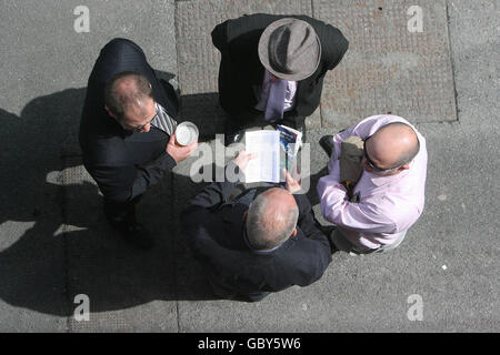 Die Spieler studieren die Form während des Sommerfestivals auf der Galway Racecourse, Galway. Stockfoto