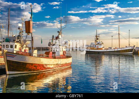 Traditionellen alten hölzernen Fischer Boote liegen im Hafen Husavik im schönen goldenen Abendlicht bei Sonnenuntergang, Island Stockfoto