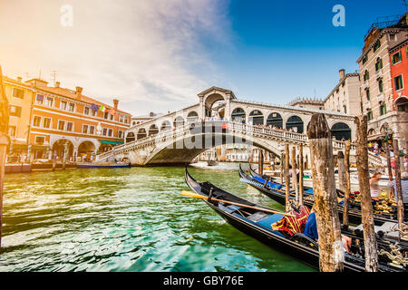 Klassische Ansicht der traditionellen Gondeln am berühmten Canal Grande mit der berühmten Rialto-Brücke bei Sonnenuntergang in Venedig, Italien Stockfoto