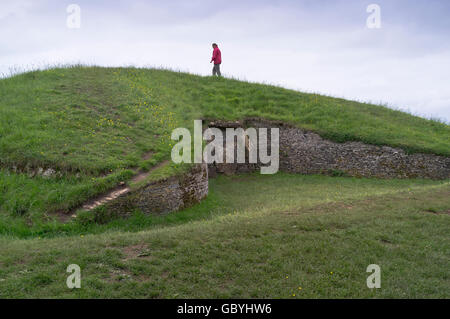 dh Cleeve Hill Belas knapp COTSWOLDS GLOUCESTERSHIRE Walker auf Steinzeithügel lange Grabkammer alte knap Hügel uk Walking Stockfoto