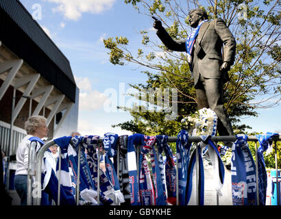 Blumenschmuck und Schals neben einer Statue von Bobby Robson vor der Portman Road, der Heimat des Fußballvereins Ipswich Town, in Erinnerung an den heute verstorbenen Fußballmanager Ipswich. Stockfoto