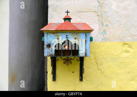 Altar mit Kerze auf griechischen Hauswand Stockfoto