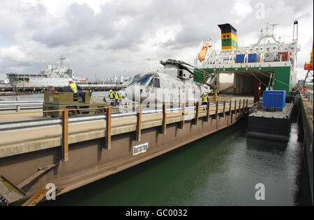 Militärangehörige des 17 Port & Maritime Regiment führen die empfindliche Operation des Abschleppens eines Merlin Hubschraubers vom modernen Logistikschiff Anvil Point am Marchwood Military Port in der Nähe von Southampton, Hampshire durch. Stockfoto