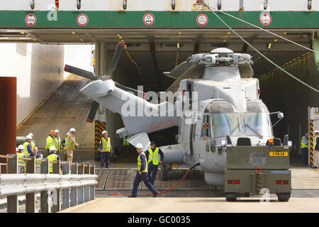 Militärangehörige des 17 Port & Maritime Regiment führen die empfindliche Operation des Abschleppens eines Merlin Hubschraubers vom modernen Logistikschiff Anvil Point am Marchwood Military Port in der Nähe von Southampton, Hampshire durch. Stockfoto