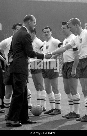 Der zukünftige Manager von England, Bobby Robson (c), sieht zu, wie Teamkollege Ron Flowers (r) mit seiner Königlichen Hoheit, dem Herzog von Edinburgh (Prinz Philip), die Hände schüttelt. Bobby Smith (zweiter rechts) schaut auf. Stockfoto