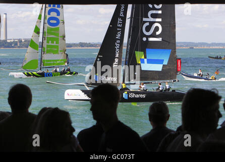 Zuschauer beobachten die iShares Cup Flotte der Extreme 40 Katamarane von der Strandbar aus am dritten Tag der Cowes Week, der weltbekannten Segelregatta, die jedes Jahr auf der Solent stattfindet. Stockfoto