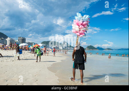 RIO DE JANEIRO - 27. Februar 2016: Brasilianischen Strand Verkäufer verkaufen Baumwolle Zuckerwatte Ansätze potenzielle Kunden, Copacabana Stockfoto