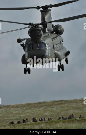Soldaten des 1. Bataillons Royal Welsh decken sich am Boden ab, wenn ein Chinook-Hubschrauber in Brecon abhebt, während sie an einer Trainingsübung vor ihrer Mission in Afghanistan Anfang Oktober teilnehmen. Stockfoto