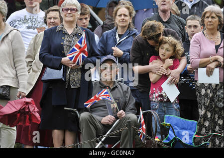 Einige Mitglieder der Menge halten Union Jack-Flaggen, während der Sarg von Harry Patch in die Wells Cathedral, Somerset, getragen wird. Stockfoto