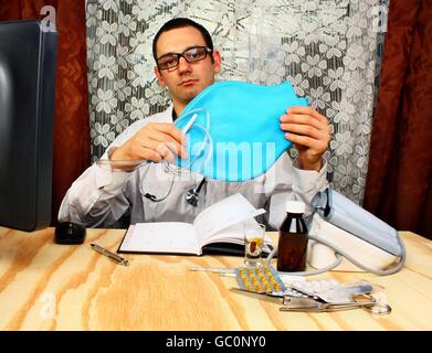 Arzt Proktologe ist weiße Medizin Uniform tragen und blauen Einlauf in den Händen halten Stockfoto