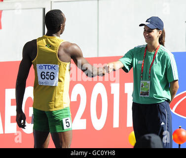 Jamaikas Usain Bolt der neue 100m-Weltmeister begrüßt seinen Helfer an den Straßensperren, als er seinen Versuch, 200m-Champion zu werden, während der IAAF-Weltmeisterschaft im Olympiastadion, Berlin, beginnt. Stockfoto