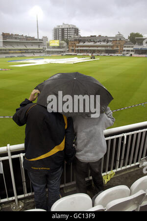 Zwei Fans schützen sich vor dem Regen während des Spiels NatWest Pro40, Division Two in Lords, London. Stockfoto