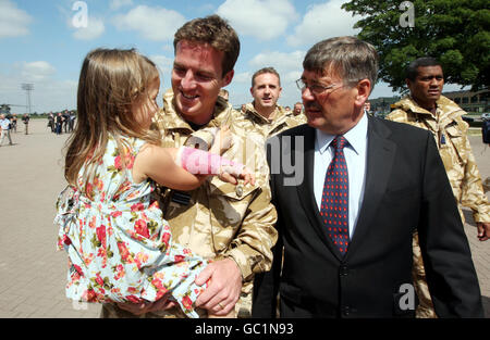 Verteidigungsminister Bob Ainsworth spricht mit Flt LT Gareth Fretwell und seiner vierjährigen Tochter Darcy, als die Staffel von Puma und Merlin aus dem Irak zur RAF Benson in Oxfordshire zurückkehrt. Stockfoto