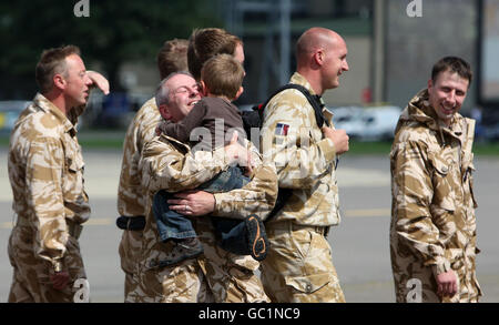 CPL Damian Duffy wird von Sohn Oliver begrüßt, als die letzten beiden Merlin-Hubschrauber vom Irak nach RAF Benson in Oxfordshire zurückkehren. Stockfoto