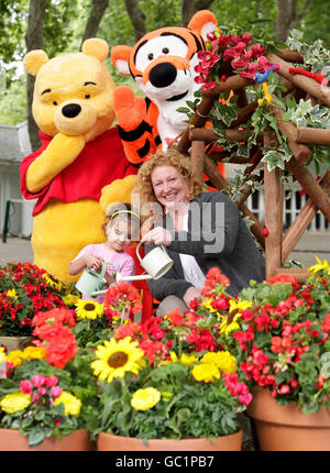 Der Fernsehgärtner Charlie Dimmock, der ihr Wissen mit grünen Fingern für eine Disney-Kampagne zur Einbeziehung von Kindern in die Gartenarbeit zur Verfügung gestellt hat, trifft auf 'Winnie-the-Pooh' und 'Tigger' in Coram's Fields im Zentrum von London mit Amaya, 3, wo im Rahmen der Initiative ein spezieller Garten geschaffen wurde. Stockfoto