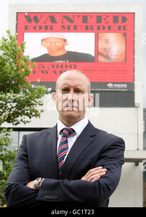 Detective Superintendent Paul Rumney, auf dem das gesuchte Plakat auf einer elektronischen Plakatwand in Piccadilly Gardens in Manchester gezeigt wird, auf der Moses Mathias, der 16-jährige Junge, der im Zusammenhang mit dem Mord an Giuseppe Gregory, der im Mai ermordet wurde, gesucht wird, gezeigt wird. Stockfoto