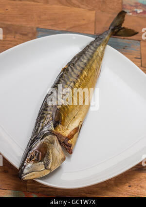 Ganze geräucherte Makrele auf einem weißen Teller Stockfoto