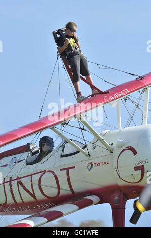 Der achtjährige Tiger Brewer wingwalks auf dem Doppeldecker seines Großvaters und in die Rekordbücher, als er der jüngste Wingwalker der Welt auf dem RFC Rendcomb Airfield in der Nähe von Cirencester wurde. Stockfoto