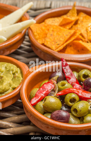 Tapas mit Manchego, marinierte Oliven, Tortilla-Chips und guacamole Stockfoto