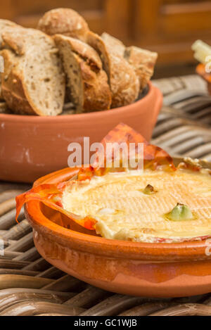 Französischer Camembert gebacken mit Knoblauch, serviert mit Brot Stockfoto