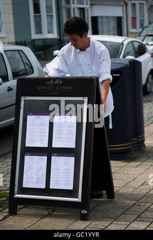Eine männliche Jungkoch Köchin Außerbetriebnahme der täglichen Speisekarte an Bord außerhalb der Gwesty Cymru fünf-Sterne-Luxus-Hotel und Restaursant, Aberystwyth Wales UK Stockfoto