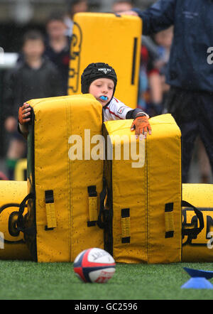 Ein Junge versucht einen Rugby-Hindernisparcours während des Edinburgh Rugby Summer Camp in Murrayfield, Edinburgh. Stockfoto