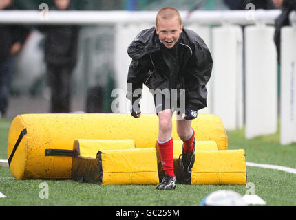 Ein Junge versucht einen Rugby-Hindernisparcours während des Edinburgh Rugby Summer Camp in Murrayfield, Edinburgh. Stockfoto