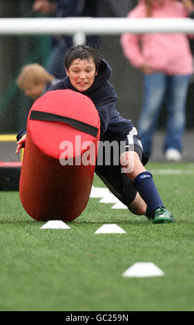 Ein Junge versucht einen Rugby-Hinderniskurs während des Edinburgh Rugby Summer Camp in Murrayfield, Edinburgh. Stockfoto