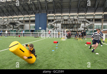 Boys versucht einen Rugby-Hindernisparcours während des Edinburgh Rugby Summer Camp in Murrayfield, Edinburgh. Stockfoto